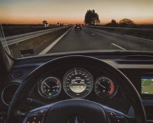 a car driving down a highway at sunset
