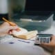 a person sitting at a desk with a calculator and a notebook