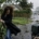Photo réaliste montrant une femme luttant contre des vents violents, tenant une branche d'arbre